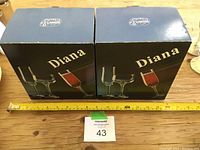 Two unopened boxes labeled Diana, each containing wine glasses, measuring approximately 10 inches in height.