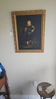 Full view of the large framed print of a boy and a puppy hung on a light colored wall.