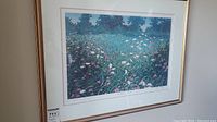 Framed and matted full view of signed print depicting a colorful wildflower meadow with trees in background.
