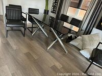 Full view of the modern dining table and chairs set in room with natural lighting.