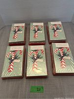 Six sealed packages of Sweeter and Orange Christmas cards with an image of candy cane and red striped ornament design on front.