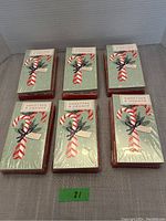 Six unopened packages of Sweetzer & Orange Christmas cards with festive candy cane and ribbon design on front