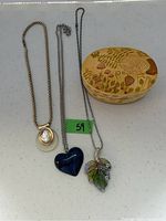 All items displayed including the three necklaces and the wooden jewelry box with mushroom and botanical design
