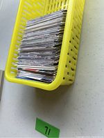 Upper Deck hockey sports cards stacked inside a yellow plastic basket from a side angle showing thickness and condition of the cards.