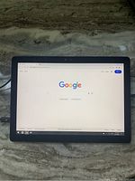 Front view of Dell Latitude tablet powered on with Google homepage displayed in browser.