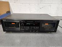 Front view of Denon DRW-660 showing dual cassette compartments and control panel.