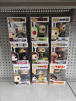 Nine boxed Funko Pops and one unboxed figure on shelf