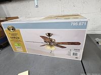 Box showing full ceiling fan image and brand details on the table