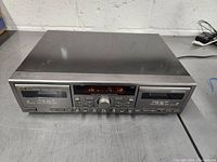 Front view of JVC TD-W709 double cassette deck showing overall unit on table with top and front visible