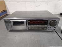 Full front view of JVC stereo cassette deck showing model markings, buttons, cassette compartment, power button, and display.