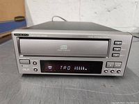 Front view of Onkyo 3 disc CD changer with disc tray closed and digital display on.