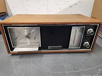 Front view of the Panasonic AM/FM clock radio showing the wood grain casing with the analog clock, radio tuner, and control knobs.
