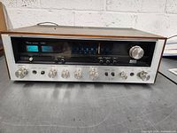 Front view showing control panel with knobs, switches, meters and tuning dial illuminated