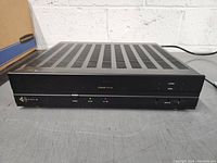 Front view showing entire amplifier unit with ventilation slots on top and front panel indicators and buttons.