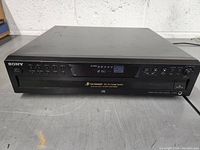 Front view of Sony 5 disc changer showing brand, control buttons, and display panel indicating disc status.