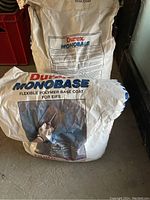 Two bags of Durex Monobase polymer base coat for EIFS, one standing and one lying down, showing product name and details.