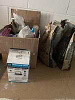 Various bags of grout and thin set mortar present in the garage, including a box of Permacolor Pro Grout in white.