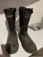 Front view of black Baffin insulated steel toe boots, showing logos and drawstring closure