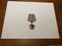 Front view of Soviet 20 Years Medal on a grey and red ribbon, showing red star and XX Roman numerals.