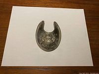 Front view of silver-tone French gorget showing detailed emblem