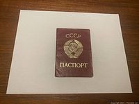 Front cover of maroon USSR passport with gold Soviet emblem and Cyrillic text on white background.