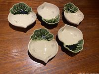 Top view of the set of 5 Japanese Oribe turnip-shaped bowls showing their cream and green glaze with decorative flower patterns inside.