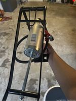 View of the Bell Air Stomper 100 foot pump showing the silver barrel and pump rod extending from the black metal foot pedal platform.