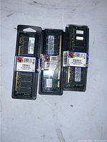 Three new memory modules sealed in original plastic packaging with part number labels