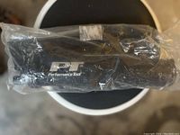 Photo of Performance Tool greaser wrapped in plastic with visible branding.