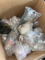 Box containing eight vintage decorative porcelain and ceramic figurines wrapped securely in bubble wrap.