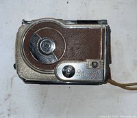Top side view showing circular film mechanism, brown leatherette covering, chrome accents, and Revere Magazine 16 engraved plate.