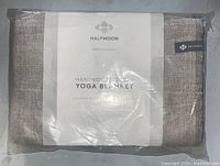 Photo of the new Halfmoon yoga blanket in its original packaging showing branding and product label.