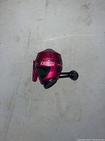 Top view of the red ZEBCO 202 Slingshot spincast fishing reel on a plain surface.