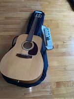 Guitar in soft shell case lying on floor with Casio VL-1 beside it