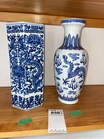 Photo showing both blue and white Asian style vases side by side with dragons and floral designs
