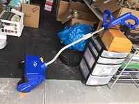 Full view of blue SnowJoe electric snow shovel showing handle and main unit.