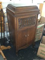 Front view of Brunswick wooden cabinet wind-up record player showing carved grille and double doors.