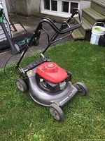 Full three-quarter view of mower showing deck, engine, wheels and handle