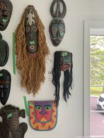 Overview of four masks mounted on wall