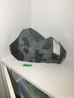 Full view of one side of the soapstone showing Inuit figure etchings and the overall stone shape and size.