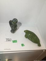 Two soapstone carvings, a bird and a seal, displayed together with size labels showing approximately 7 inches.