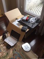 Overview of all items including turntable on box, laptop, amplifier, and receiver on floor near window.