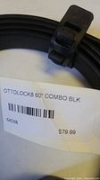Close-up photo of price tag and part of the lock cable showing 'OTTOLOCK8 60" COMBO BLK' label and pricing at $79.99.