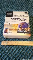 Front of the Sony 3D Starter Pack box showing branding and included items depicted in graphics, with a ruler for scale.