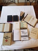 Overview of 10 Bibles and prayer books laid out on table showing variety of sizes and covers.