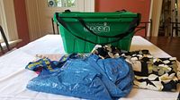 Lot showing two green hard plastic grocery totes, blue IKEA reusable tote bag and black reversible cloth bag