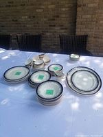 Overview of entire dinnerware set arranged on table; numbered stickers indicate count by piece type