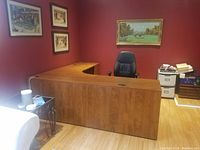 Full view of the L-shaped desk in a home office setting, showing the wood finish and corner design.