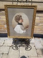 Front view of the vintage alterboy picture in its decorative gold-toned frame, showing details of the clothing and facial profile of the alterboy.