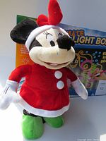Mini Mouse holiday ornament dressed in red and white costume, standing in front of Crayola Ultimate Light Board box